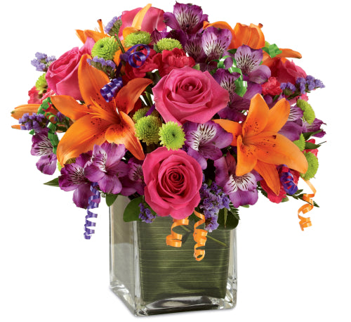 Roses, lily and seasonal flowers arranged together in cube vase.