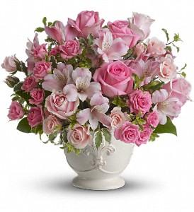 Pink flowers suitable for sympathy flowers, arranged in white container. 