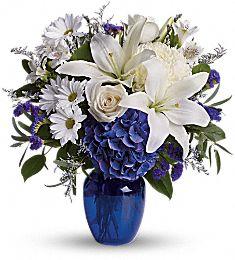 Lily and roses arranged in blue vase by your florist of choice in Winnipeg-Valley flowers