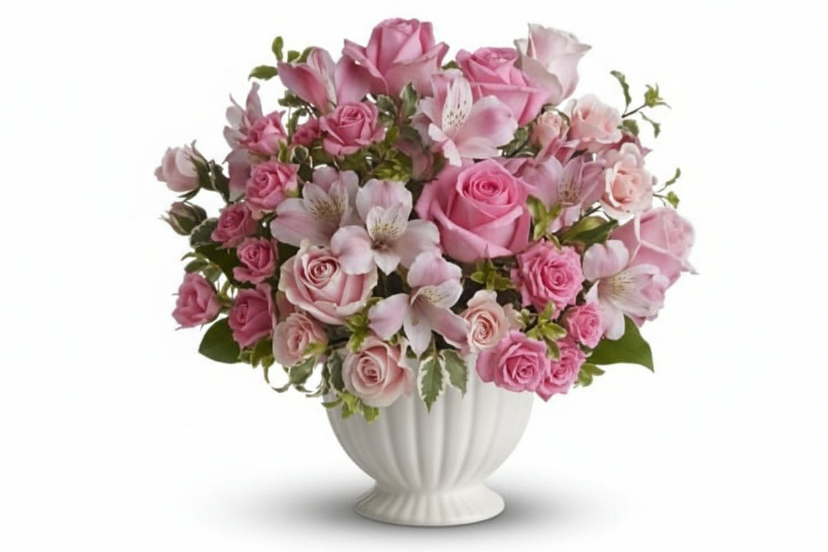 Pink flowers suitable for sympathy flowers, arranged in white container. 