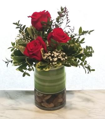 Broadway flowers include roses and greens in simple cylinder vase.